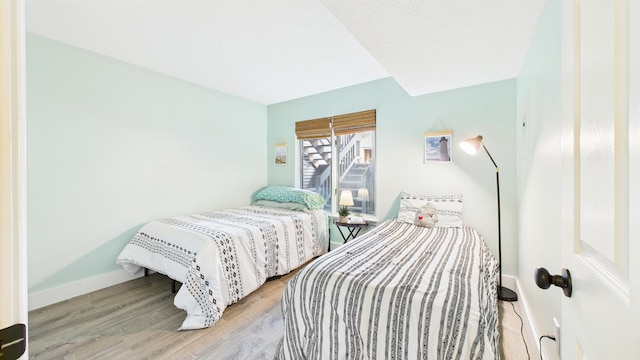 bedroom with baseboards and wood finished floors