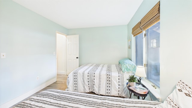 bedroom with baseboards and wood finished floors