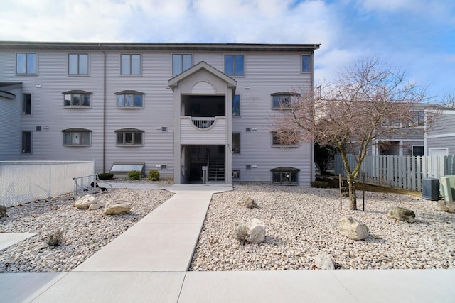 view of property featuring fence and central AC unit