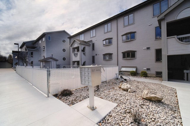 exterior space featuring fence and mail area