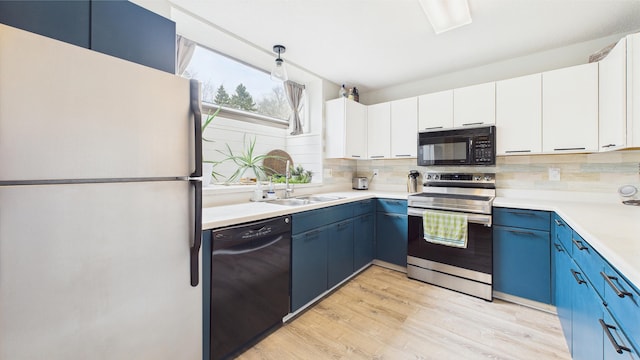 kitchen with backsplash, blue cabinetry, black appliances, and light countertops
