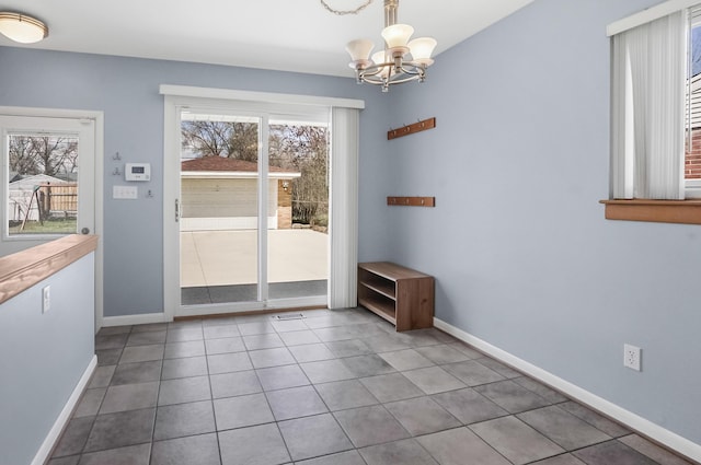 doorway to outside featuring baseboards, tile patterned floors, and a chandelier
