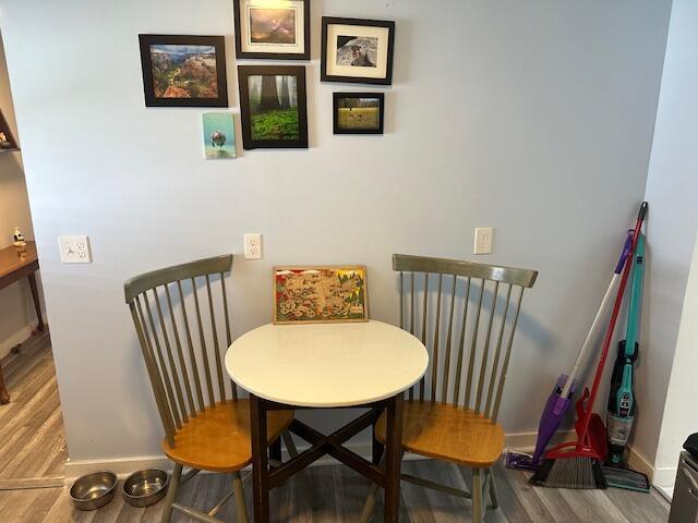 dining space with baseboards and wood finished floors