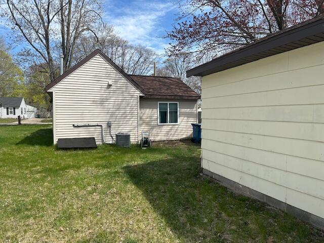 view of home's exterior with a lawn and central AC unit