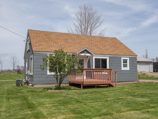 back of property featuring roof with shingles, a lawn, central AC, and a deck