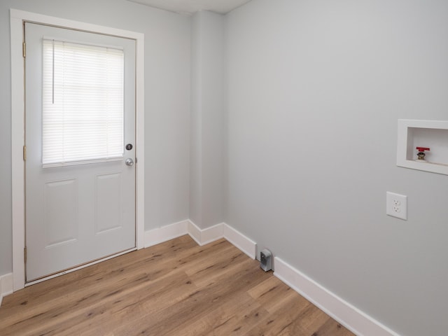 interior space with baseboards, laundry area, light wood-style flooring, and hookup for a washing machine