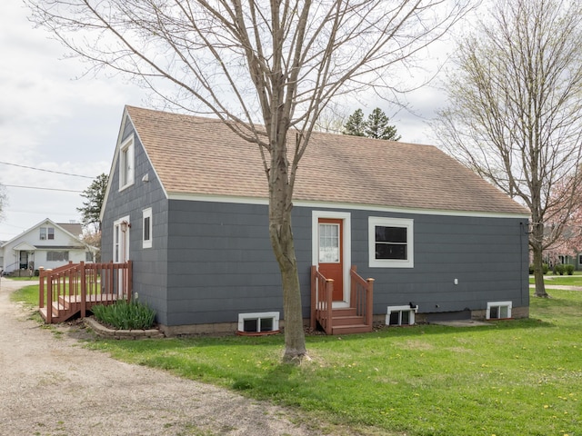 rear view of house featuring entry steps, central AC unit, a lawn, and roof with shingles