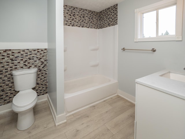 full bathroom with vanity, wood finished floors, toilet, and tile walls