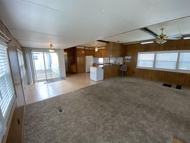 kitchen featuring freestanding refrigerator, ceiling fan, brown cabinets, and open floor plan