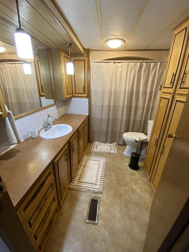full bathroom with visible vents, vanity, toilet, a shower with shower curtain, and a textured ceiling