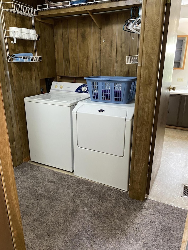 laundry area featuring separate washer and dryer, laundry area, and carpet floors
