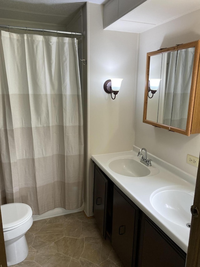 bathroom with a sink, a shower with curtain, toilet, and double vanity