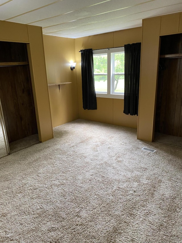 unfurnished bedroom featuring carpet floors and visible vents