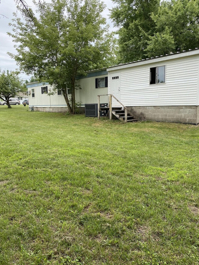 rear view of house featuring a lawn, central air condition unit, and entry steps