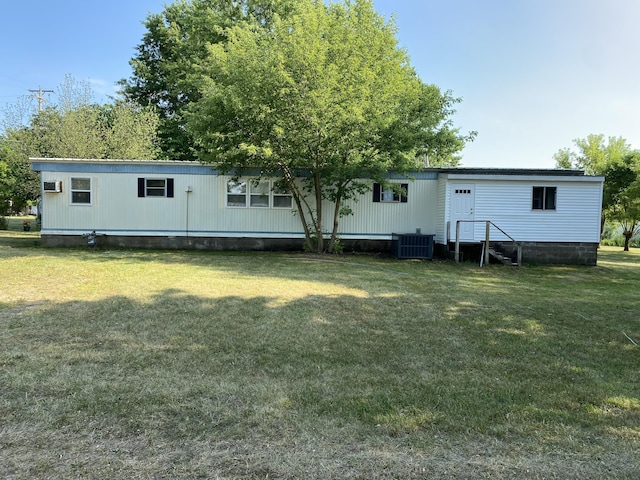 rear view of house featuring central AC unit and a yard