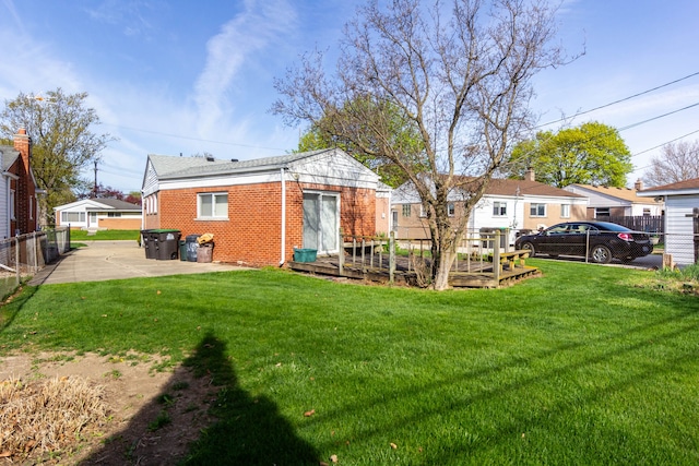 back of property with a yard, brick siding, fence, and a patio