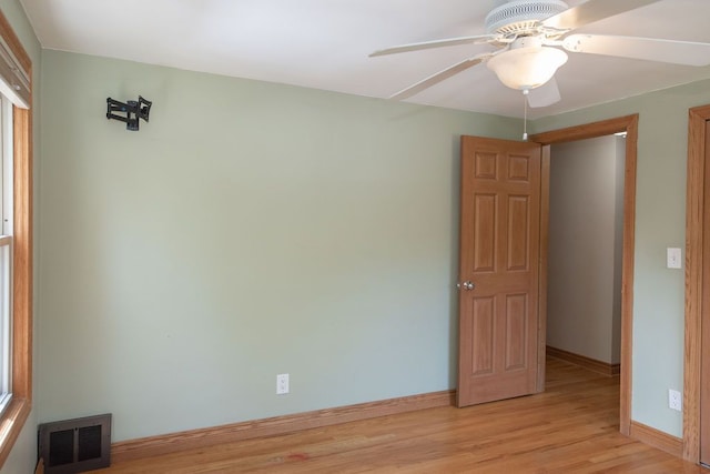 unfurnished room featuring baseboards, light wood finished floors, and a ceiling fan