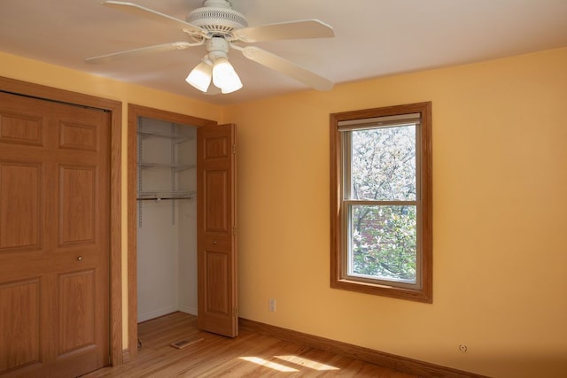 unfurnished bedroom featuring light wood-style flooring, baseboards, a closet, and a ceiling fan