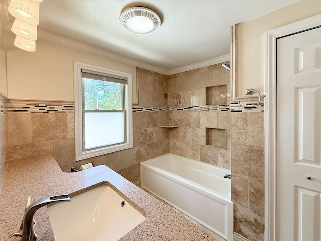 full bathroom featuring tile walls, a sink, crown molding, and tub / shower combination