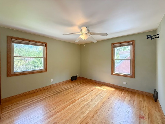 empty room with light wood-type flooring, baseboards, and a ceiling fan
