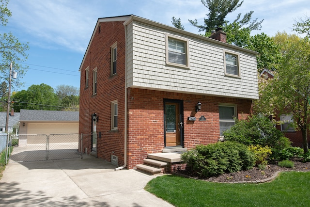 view of front of property featuring brick siding, a chimney, a detached garage, and a gate