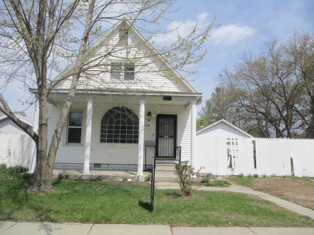 view of front of home with a front lawn, fence, and covered porch