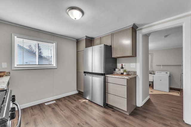2040 Freeman St, Westland, MI 48186 - kitchen featuring visible vents, wood finished floors, baseboards, washer / dryer, and stainless steel appliances