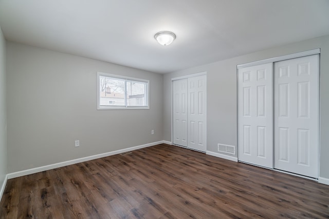 2040 Freeman St, Westland, MI 48186 - unfurnished bedroom featuring visible vents, baseboards, two closets, and dark wood finished floors