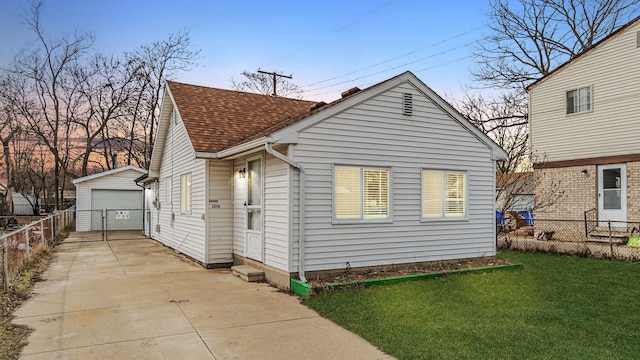 2040 Freeman St, Westland, MI 48186 - view of front of house featuring a garage, a shingled roof, fence, and an outbuilding