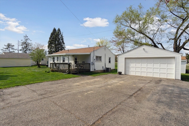 view of front facade featuring a wooden deck, a detached garage, central air condition unit, an outdoor structure, and a front lawn