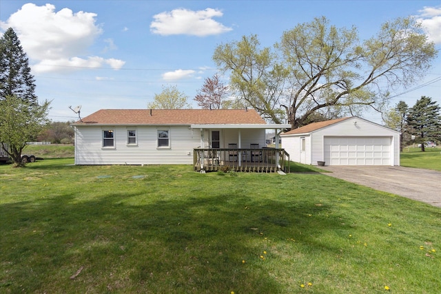 back of property with a garage, an outbuilding, a lawn, and a deck