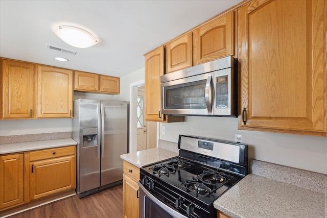 kitchen with visible vents, dark wood-style flooring, and appliances with stainless steel finishes