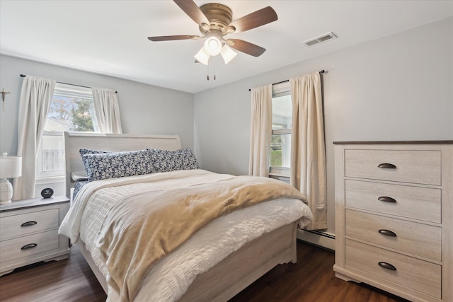 bedroom with ceiling fan, visible vents, and dark wood-type flooring
