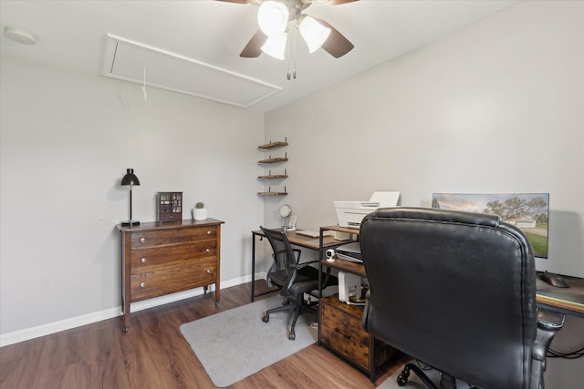office area featuring baseboards, ceiling fan, attic access, and wood finished floors