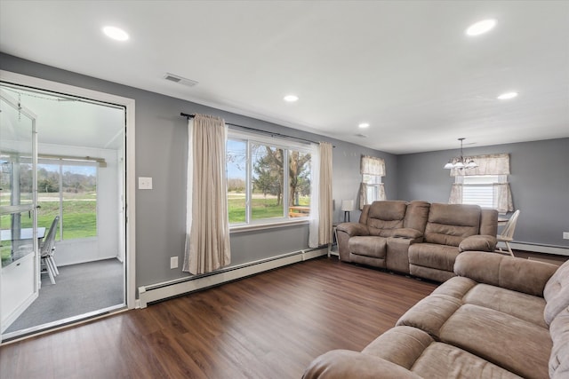 living area featuring dark wood-style flooring, a baseboard heating unit, a chandelier, and recessed lighting