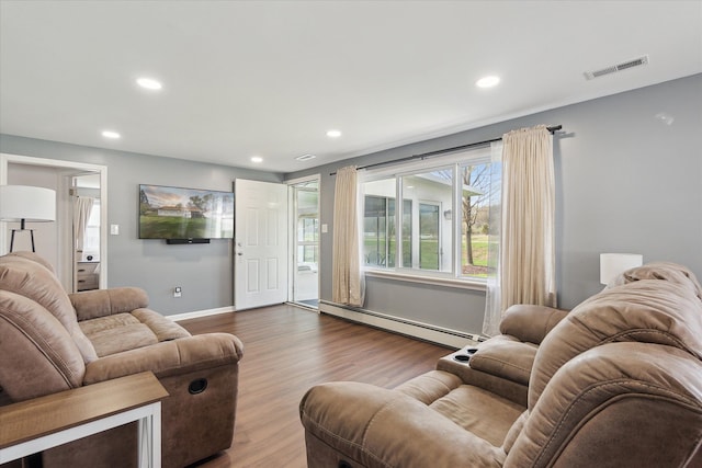 living room with visible vents, recessed lighting, dark wood-style flooring, and a baseboard heating unit