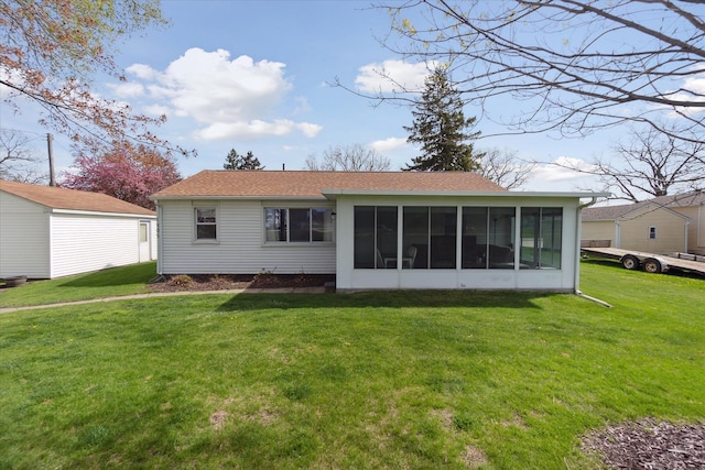 back of property featuring a sunroom, a shingled roof, and a yard