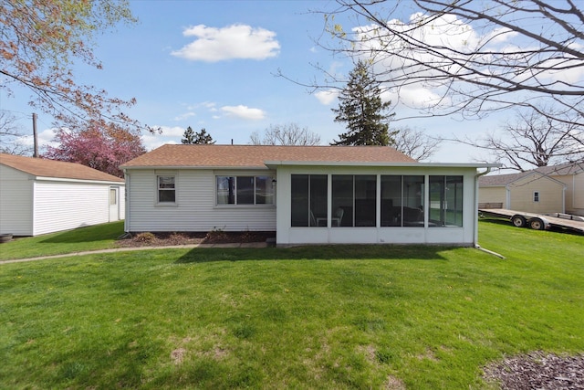 rear view of property featuring a sunroom, roof with shingles, and a yard