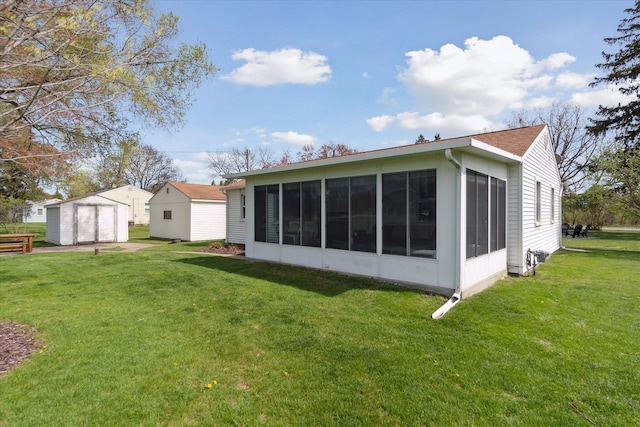 rear view of property with a garage, a sunroom, an outdoor structure, and a yard