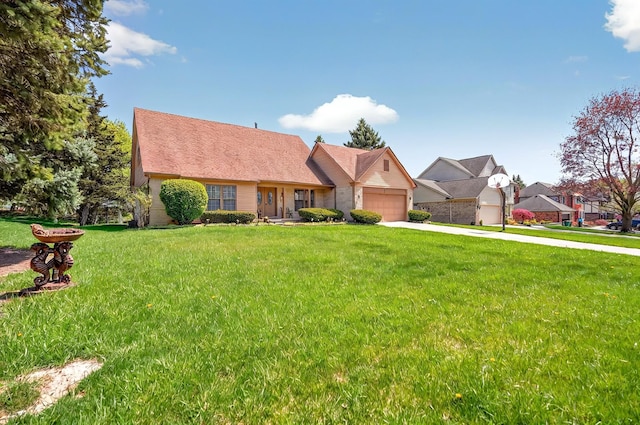 view of front of home featuring an attached garage, driveway, and a front lawn