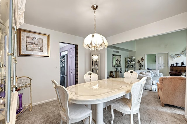 dining area featuring light colored carpet, baseboards, a chandelier, and visible vents