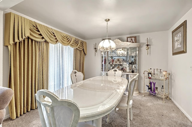 dining space with baseboards, a chandelier, and light carpet