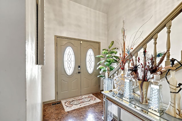 foyer with visible vents and a towering ceiling