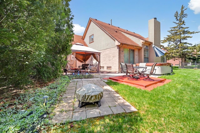back of house featuring brick siding, a patio, a gazebo, and a chimney