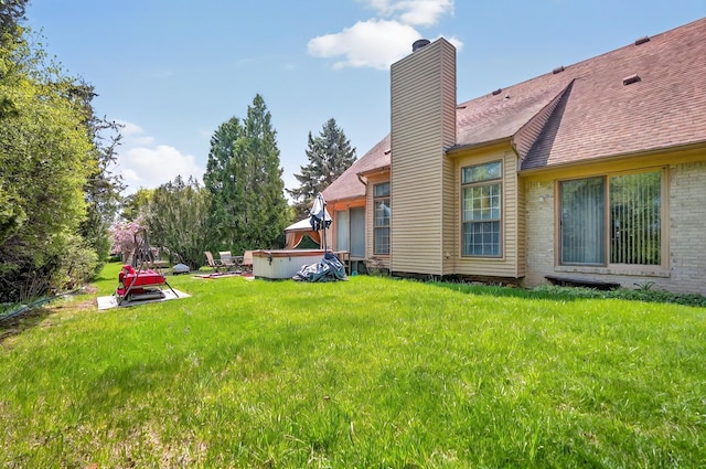 rear view of house featuring a lawn and a chimney