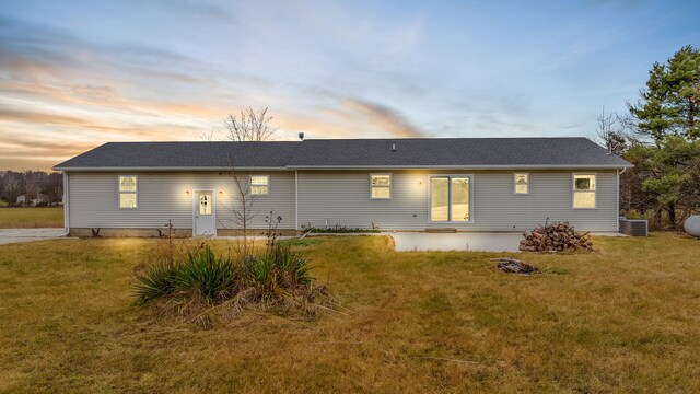 back of house featuring a lawn and central AC