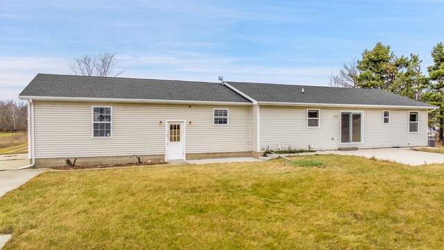 rear view of house featuring a lawn, entry steps, and a patio area