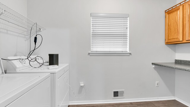 laundry room with visible vents, wood finished floors, cabinet space, baseboards, and washer and clothes dryer