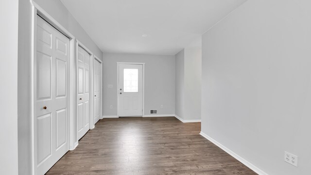 entryway with visible vents, dark wood-style flooring, and baseboards