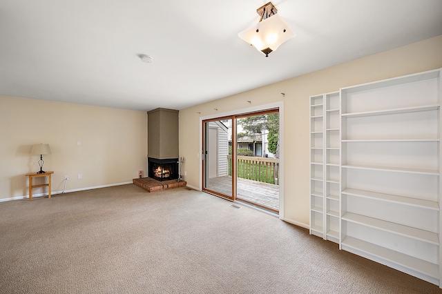 interior space with carpet floors, baseboards, visible vents, and a large fireplace